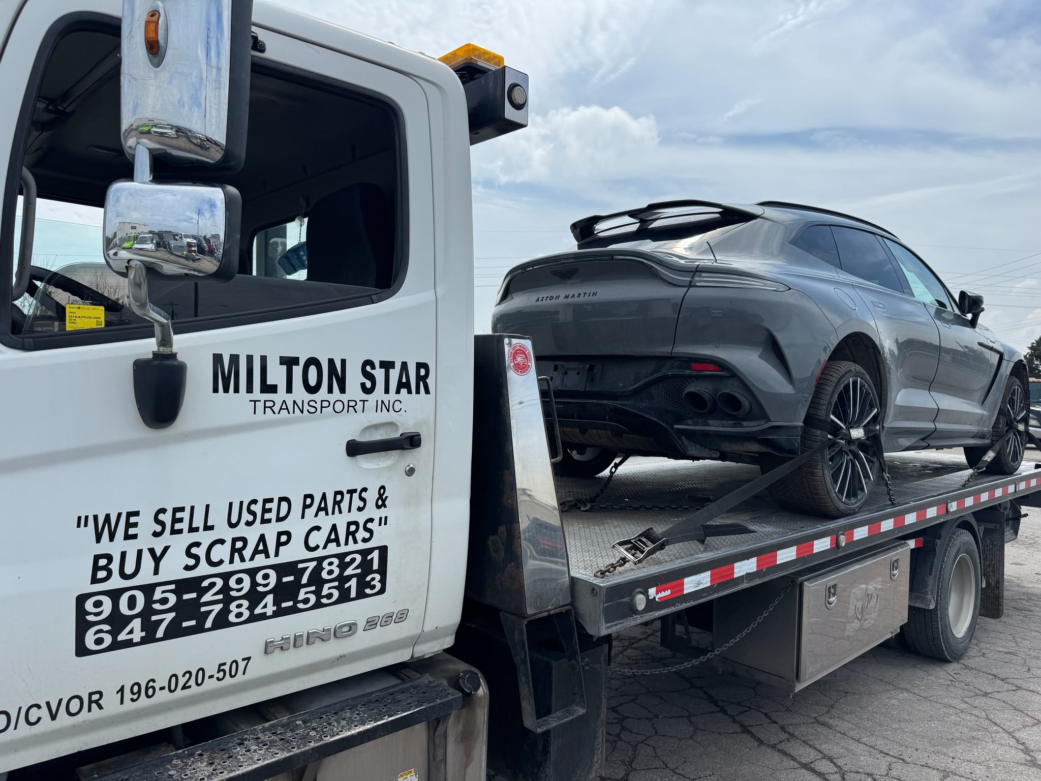 Milton Start Towing flatbed tow truck hauling an Aston Martin